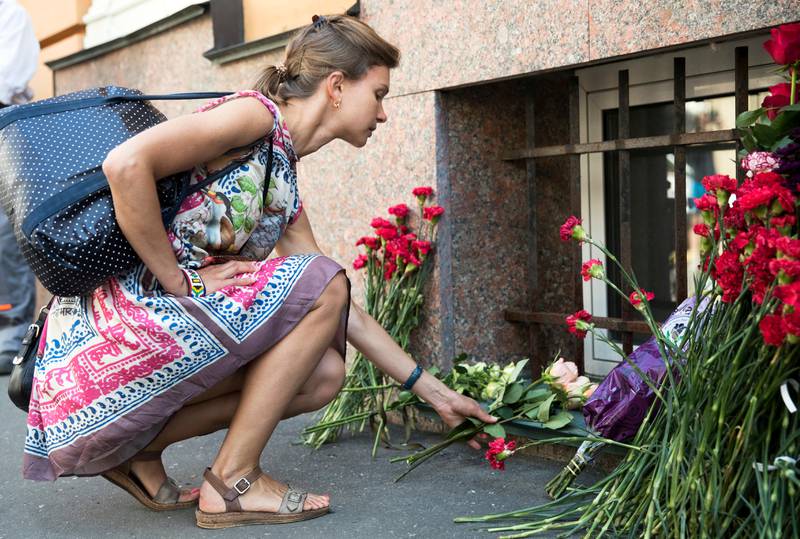 A woman lays flowers in front of the Spanish embassy in Moscow, Russia, Friday, Aug. 18, 2017 for the victims of the Thursday's terrorist attacks in Spain. Catalonia's regional president says that there's at least one "terrorist still out there" after the attacks in Barcelona and a seaside resort. (AP Photo/Pavel Golovkin)