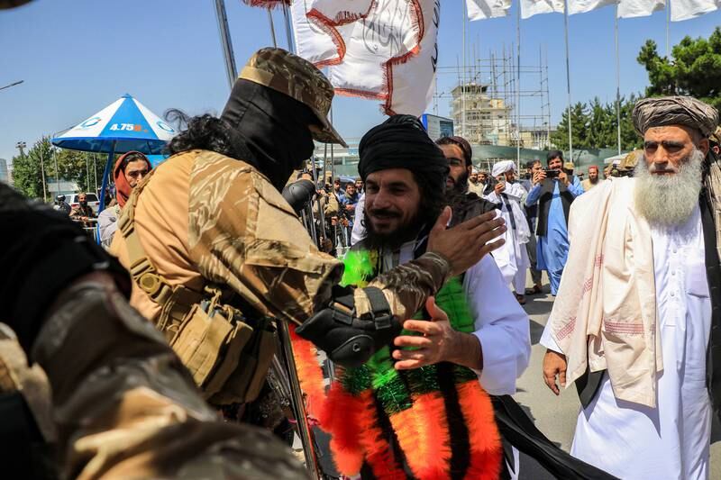 The Taliban greet Asadullah Haroon, centre, one of the two Afghans detained at Guantanamo Bay, as he arrives in Kabul, in June. EPA
