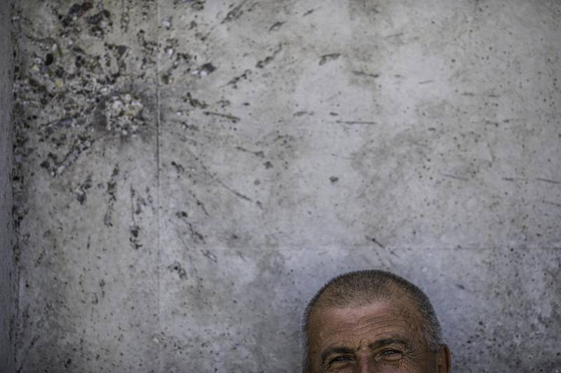 A man rests under a scar from a war-time projectile on the building where remains of victims of the Srebrenica genocide are placed in Potocari near Srebrenica, Bosnia and Herzegovina. Getty Images