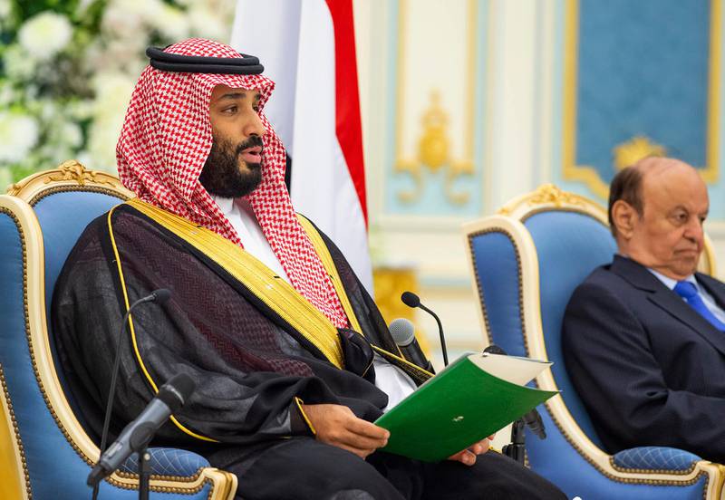 In this photo released by Saudi Royal Palace, Saudi Arabia's Crown Prince Mohammed bin Salman, left, and Yemen's President Abed Rabbo Mansour Hadi, attend the signing a power-sharing deal between Yemen's internationally recognized government and Yemeni separatists that are backed by the United Arab Emirates, in Riyadh, Saudi Arabia, Tuesday, Nov. 5, 2019. At top is a picture of Saudi Arabia's founder late King Abdul Aziz Al Saud. (Bandar Aljaloud/Saudi Royal Palace via AP)
