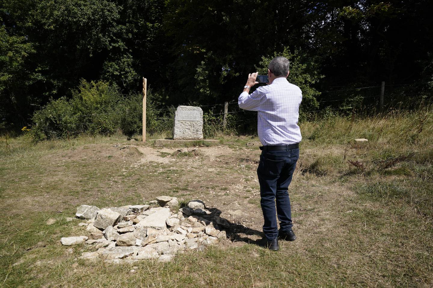 A man photographs the stone marking the spot for the traditional source of the River Thames known as Thames Head. PA