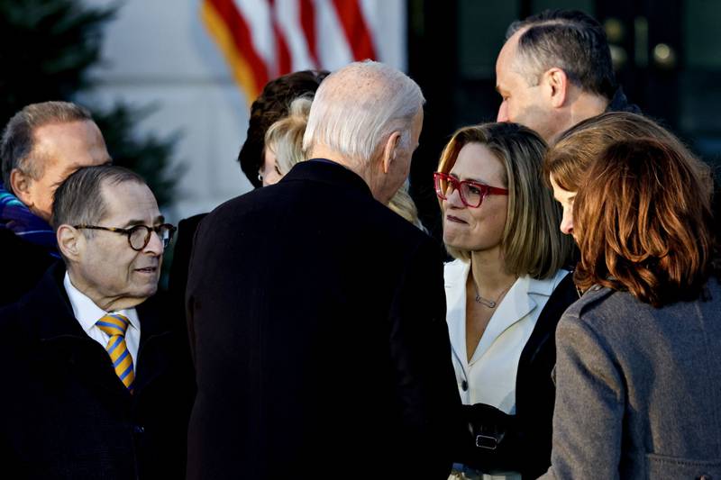 Mr Biden speaks with Ms Sinema during the ceremony. Bloomberg 