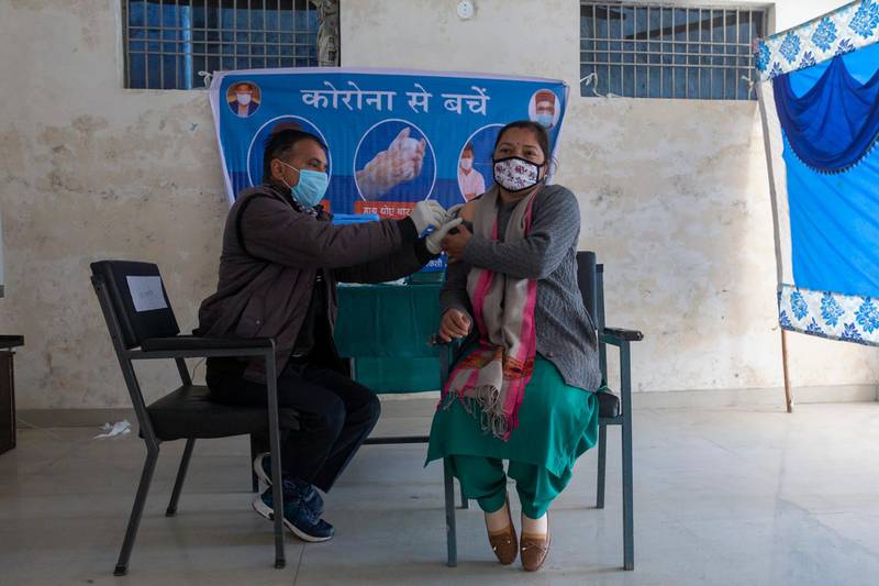 A health official pretends to administer a shot of Covid-19 vaccine to a volunteer during a mock vaccination drill at a school, in Dharmsala, India. AP Photo