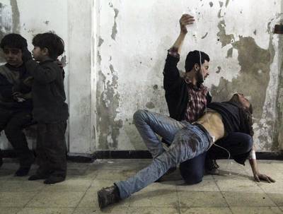 A man gives medical assistance to an injured man as two wounded children wait nearby at a field hospital after what activists said was an air strike by forces of Syria's President Bashar al-Assad in the Duma neighbourhood of Damascus, Syria.  Mohammed Badra / Reuters