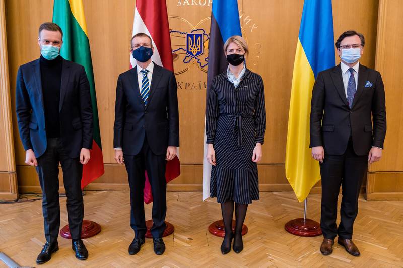 In this handout photo released by Ukrainian Foreign Ministry Press Office, from left, Lithuanian Foreign Minister Gabrielius Landsbergis, Latvian Foregn Minister Edgars Rinkevics, Estonian Foreign Minister Eva-Maria Liimets and Ukrainian Foreign Minister Dmytro Kuleba pose for a photo prior to their talks in Kyiv, Ukraine, Thursday, April 15, 2021. Ukraine's top diplomat is asking for stronger Western backing amid escalating tensions in the country's east and a Russian troop buildup across the border. Ukrainian Foreign Minister Dmytro Kuleba said after talks with his counterparts from Estonia, Latvia and Lithuania that "words of support aren't enough." (Ukrainian Foreign Ministry Press Office via AP)