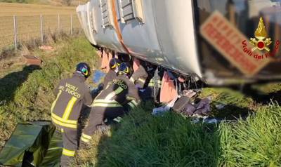 Rescuers work at the site of an accident after a bus that was carrying about 50 Ukrainian refugees overturned near Forli, central Italy. One person died in the crash. AFP
