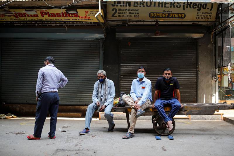 Shopkeepers wait to open their stores at a market area after authorities eased lockdown restrictions in New Delhi.