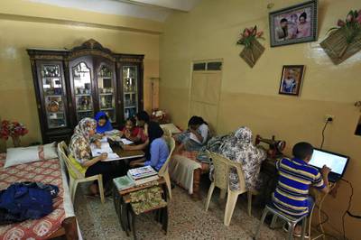 This picture taken on March 23, 2020 shows members of a family studying together at home in Khartoum, as schools and universities close as a preventive measure against the spread of the COVID-19 novel coronavirus.  / AFP / Ashraf SHAZLY

