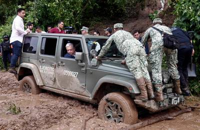 Mexican President Andres Manuel Lopez Obrador looks out of the window as his vehicle gets stuck in mud during a visit to the Kilometro 42 community, after Hurricane Otis hit Acapulco. AFP