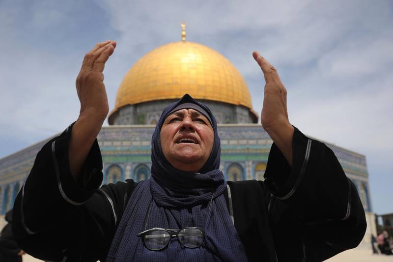 A Palestinian woman prays, with the Dome of the Rock shrine in the background. AP Photo