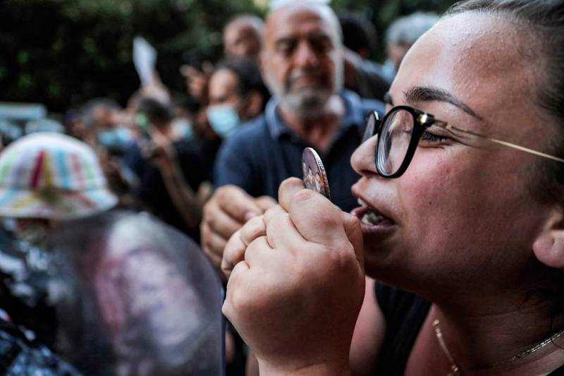 A protester holds up an image of three of the Beirut blast victims during a demonstration outside the residence of Lebanon's interior minister in the Qoraitem neighbourhood of western Beirut.