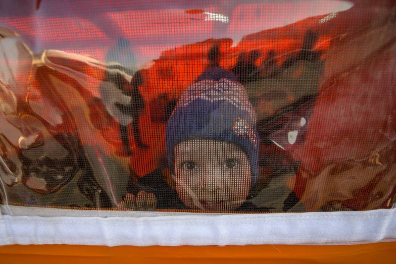 A young Ukrainian refugee looks out of a tent after crossing the border by ferry into Romania on March 24, 2022. AP