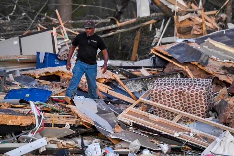 James Ezell, a survivor, looks through the remains of a destroyed home in Wren.   EPA