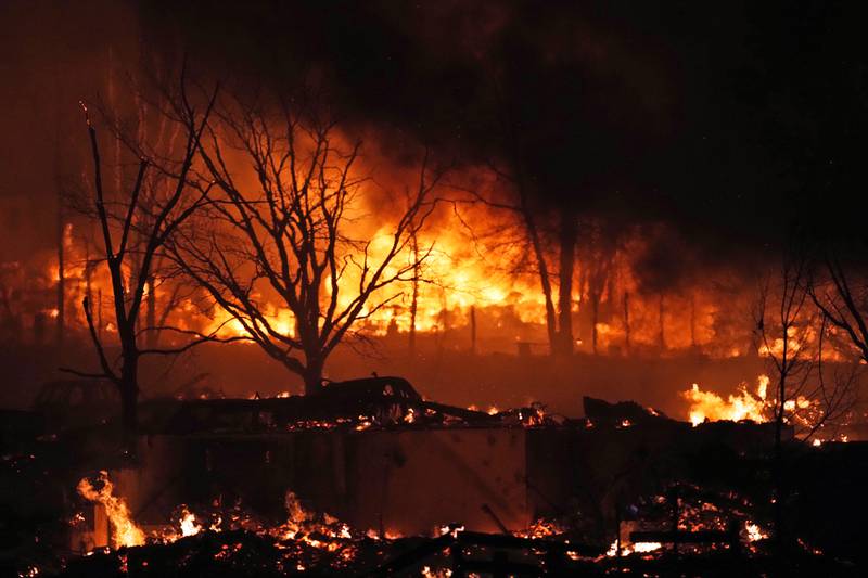 Trees are silhouetted against a raging fire at Rock Creek village near Broomfield, Colorado. AP