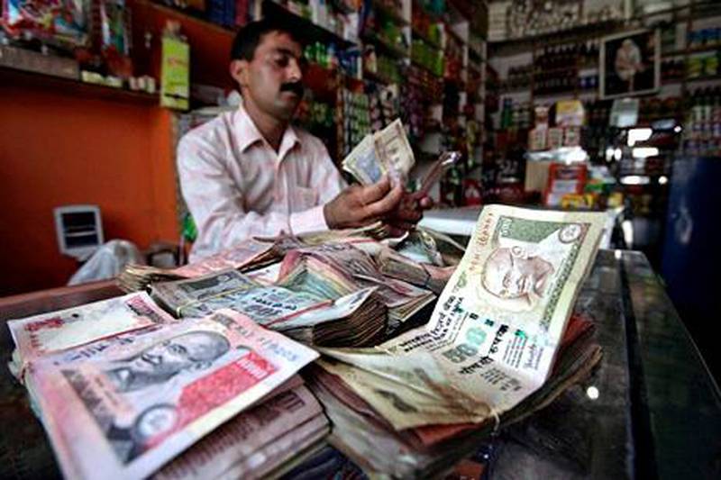 A shopkeeper counts Indian currency notes inside his shop in Jammu July 14, 2010. The Indian rupee strengthened on Wednesday as risk appetite returned to markets globally, helping local shares gain over 1 percent in early trade, with the dollar's weakness against majors also boosting sentiment. REUTERS/Mukesh Gupta (INDIAN-ADMINISTERED KASHMIR - Tags: BUSINESS) *** Local Caption ***  DEL03_MARKETS-INDIA_0714_11.JPG