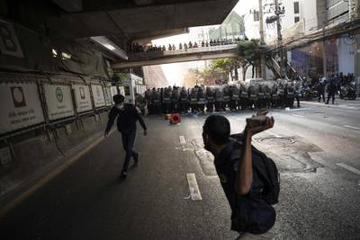 A demonstrator prepares to throw a rock towards riot police during a protest outside the Embassy of Myanmar in Bangkok, Thailand. Andre Malerba/Bloomberg