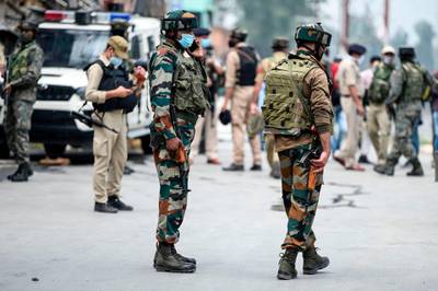 Security personnel stand guard near the site where suspected militants fired at police near Nowgam bypass in Srinagar. At least two policemen were killed and another wounded after militants allegedly opened fire on police party in Nowgam area, local media reported on August 14.  AFP