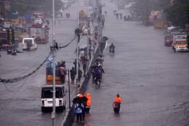 Commuters make their way along a flooded road during heavy rains in Chennai as Cyclone Michaung approached India's eastern coast. EPA