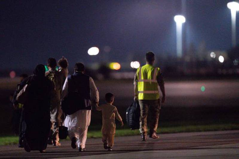 British nationals and Afghan evacuees leave a rescue flight from Kabul at a UK military base in Brize Norton, England. Getty