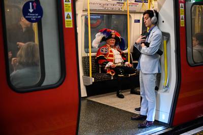 Town crier Tony Appleton takes the train into central London. AFP