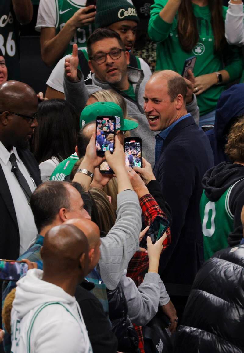Fans take pictures of Prince William during halftime. EPA