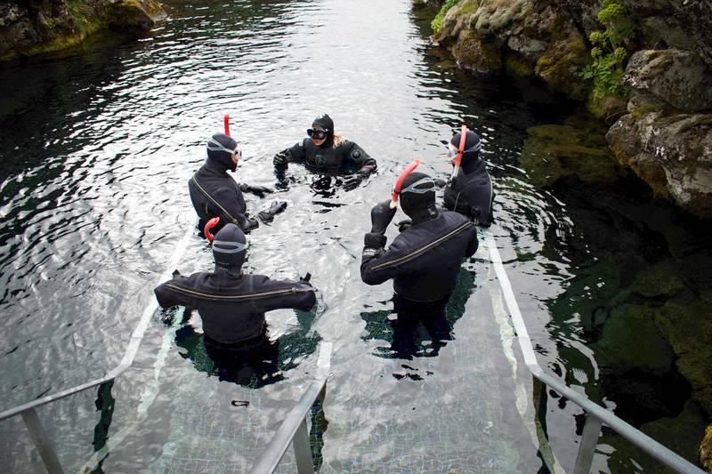 A diving instructor gives instructions before tourists plunge into the icy waters. Photo: Jeremie Richard / AFP