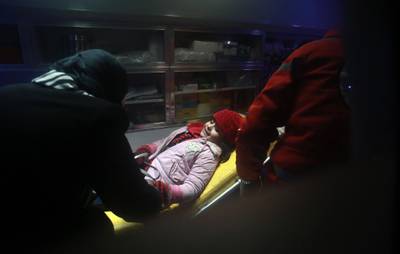 A Syrian girl lies inside an ambulance. Abdulmonam Eassa / AFP Photo