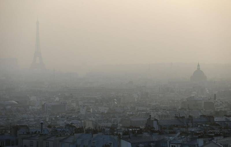 (FILES) This file photo taken on March 11, 2014,  shows the Eiffel tower and the Paris rooftops through a haze of pollution. The world must slash its emissions of planet-warming greenhouse gases by 7.6 percent every year to 2030 or miss the chance to avert devastating climate change, the United Nations said on November 26, 2019. In its annual Emissions Gap report, the UN's Environment Programme said anything short of a drastic and immediate drawdown in fossil fuel use worldwide would put the Paris treaty temperature cap of 1.5C "out of reach". / AFP / PATRICK KOVARIK
