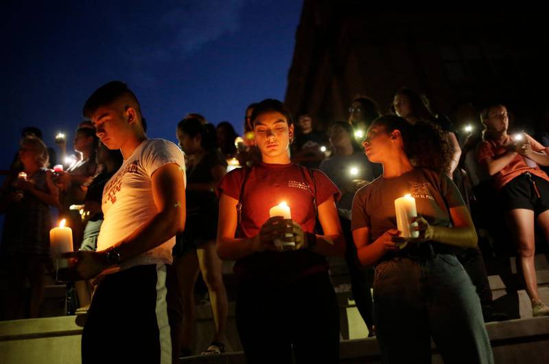 Samuel Lerma, Arzetta Hodges and Desiree Qunitana join mourners taking in a vigil at El Paso High School. Reuters