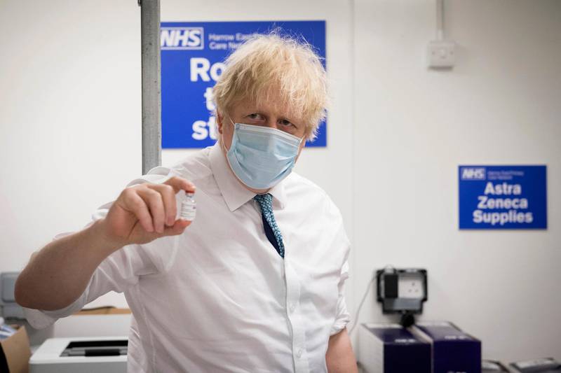 Britain's Prime Minister Boris Johnson holds a vial of the Oxford/AstraZeneca vaccine during a visit to Barnet FC's ground, which is being used as a coronavirus vaccination centre in London. AP Photo