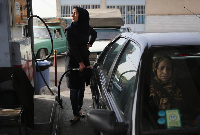 A woman fills her gas tank at a service station in Shahinshahr.