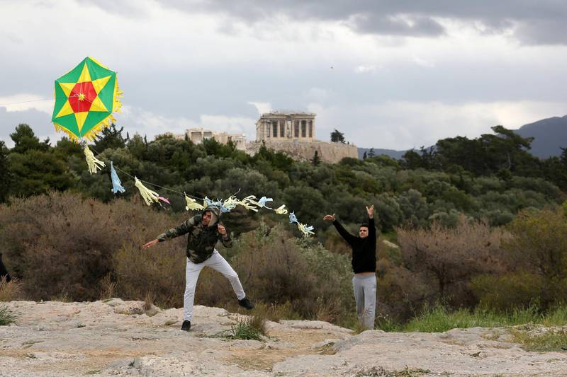 People fly a kite during celebrations of Clean Monday at Filopappou hill as the Parthenon temple is seen atop the Acropolis hill in Athens, Greece. Reuters