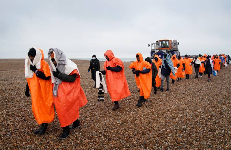 Migrants on a beach in Dungeness, Kent, after being rescued by a British lifeboat. PA