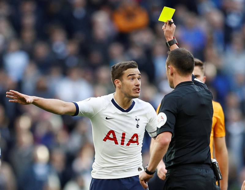 Tottenham Hotspur's Harry Winks is shown a yellow card by referee Stuart Attwell in the home defeat to Wolves. Reuters