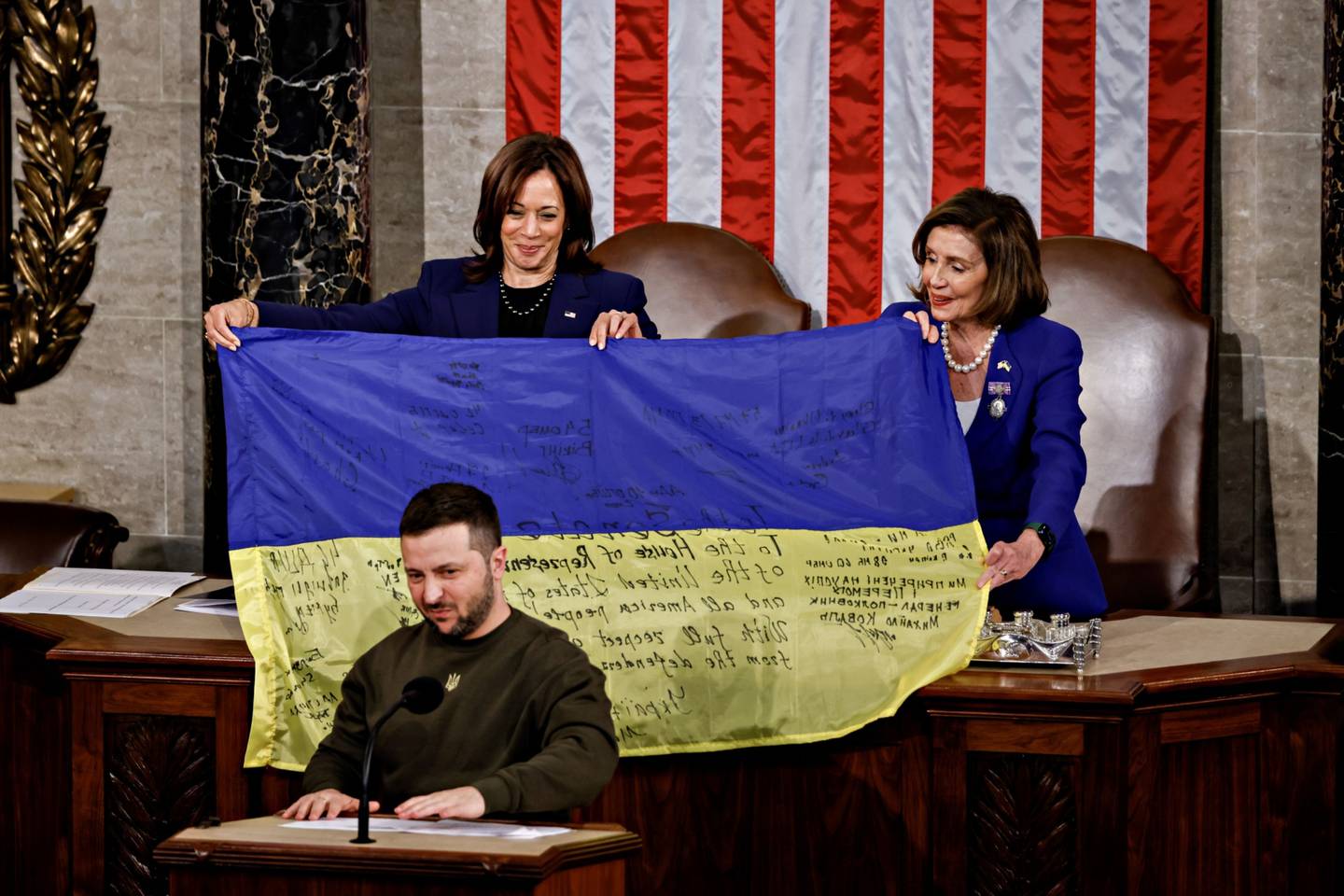 US House Speaker Nancy Pelosi, right, and US Vice President Kamala Harris, left, hold a Ukrainian flag signed by soldiers in war-torn Bakhmutto after being presented by Volodymyr Zelenskyy, at the US Capitol in Washington, on December 21. Bloomberg 