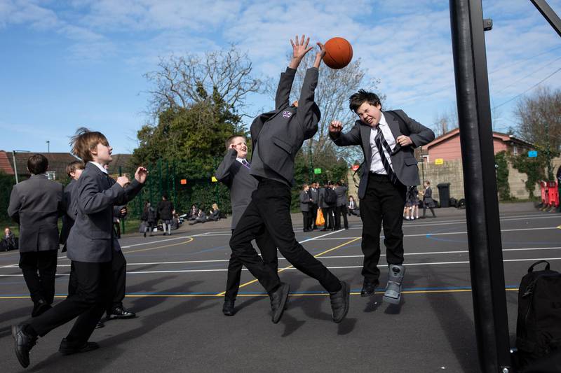 Pupils gather in the playground for a break on their first day back from lockdown at Chertsey High School. Getty Images