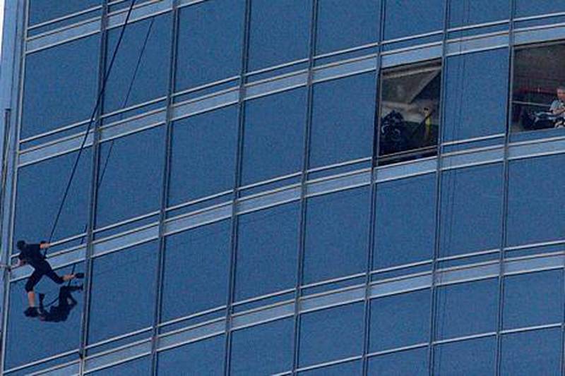 Crew members stand by as Tom Cruise hangs off the Burj Khalifa during filming. Pawan Singh / The National