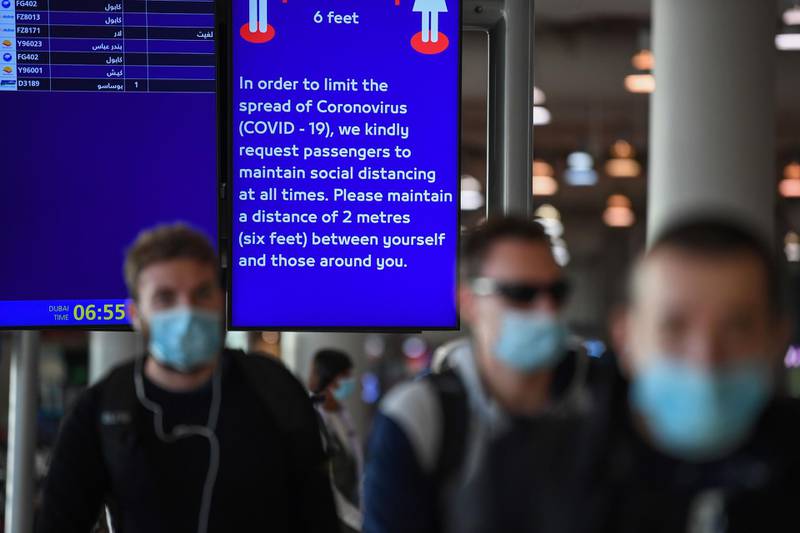 An information board displays an alert for passengers to maintain distance from others at Dubai International Airport. AFP