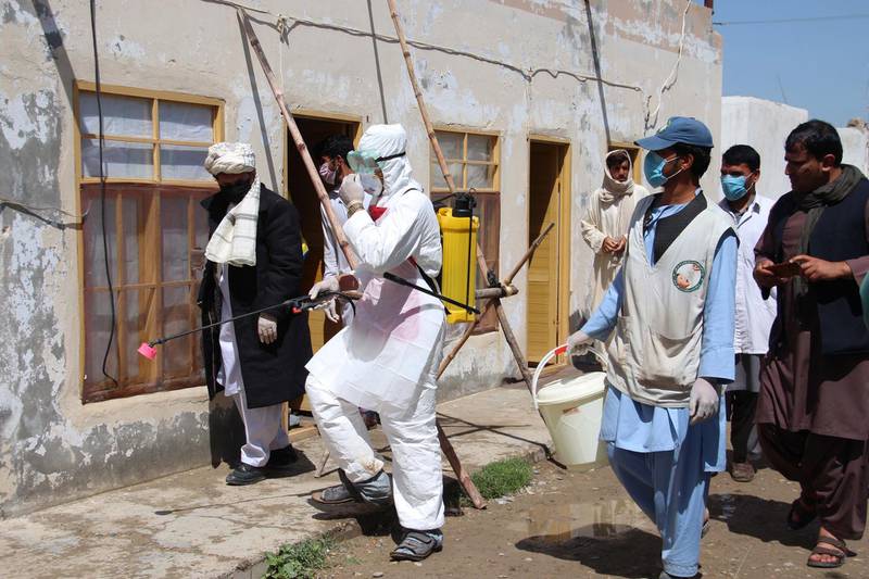 Afghan health workers spray disinfectants at public places in Helmand, Afghanistan.  EPA