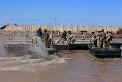 (FILES) In this file photo taken on March 06, 2017 international coalition forces and Iraqi soldiers instal a floating bridge at the Taji camp, north of Baghdad, during a training session. Katyusha rockets targeted an Iraqi airbase north of Baghdad hosting US-led coalition forces, the Iraqi military said on January 14, 2020 in the latest attack on installations where American troops are deployed. The statement from Iraq's military did not say how many rockets had hit Camp Taji but reported that there were no casualties. / AFP / SABAH ARAR
