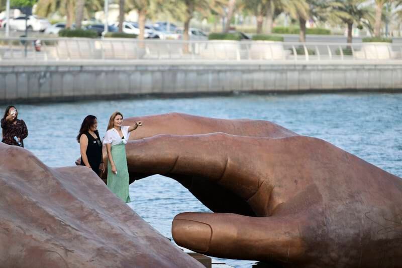 Visitors take photos near a giant sculpture submerged at Yas Bay Waterfront during Eid Al Fitr in Abu Dhabi. All photos: Khushnum Bhandari / The National
