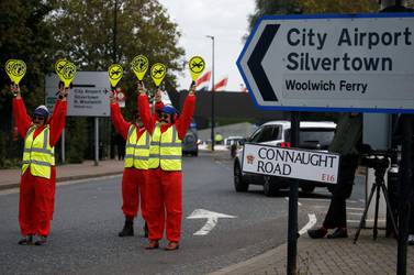 Extinction Rebellion protesters dressed as airport marshalls block the road during a demonstration, near London City Airport, in London, Britain, October 10, 2019. REUTERS/Henry Nicholls