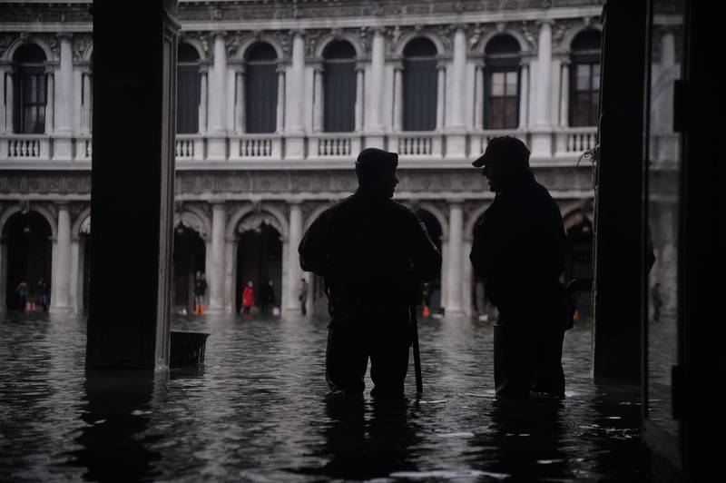 Persons stand in floods in Venice, in the morning of November 17. Filippo Monteforte / AFP
