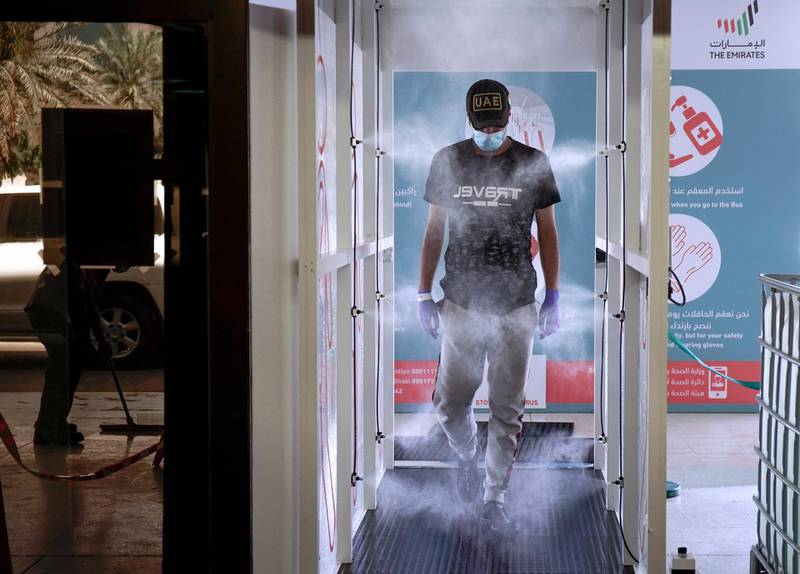 Abu Dhabi, United Arab Emirates, March 31, 2020.   A commuter enters the new sterilization area  and gets sprayed at the entrance of the Abu Dhabi Central Bus Terminal.Victor Besa / The NationalSection:  NAReporter: