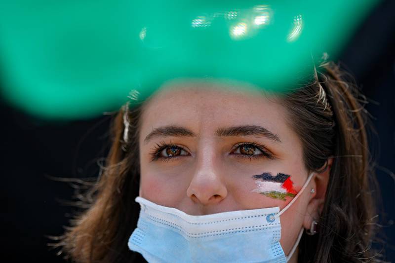 A woman, her face painted with the Palestinian flag, joins a protest in Bucharest, Romania. AP Photo
