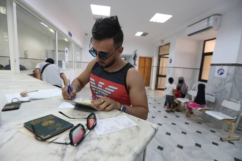 An Algerian fills out travel documents at the reopened Malloula border post before entering Tunisia. EPA