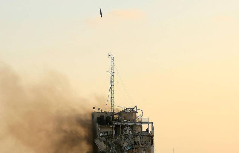 An air guided bomb can be seen hitting Al-Sharouk tower as it collapses during an Israeli air strike, in Gaza City on May 12, 2021. An Israeli air strike destroyed a multi-storey building in Gaza City today, AFP reporters said, as the Jewish state continued its heavy bombardment of the Palestinian enclave. AFP