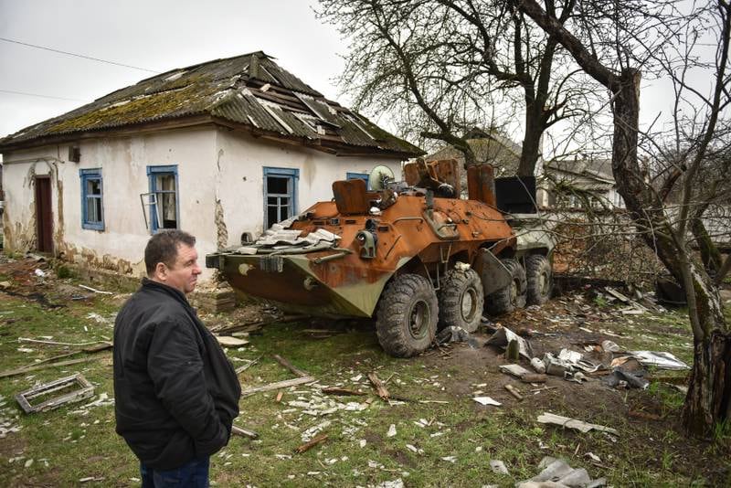 A man looks at a burned APC in Yahidne, Chernihiv. EPA