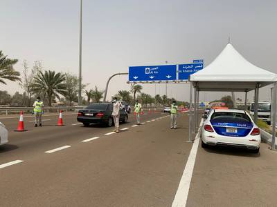 Officers check motorists for travel permits as they enter Abu Dhabi from Dubai. Courtesy: AD Police