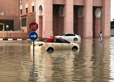 Cars in Dubai's Ibn Batutta Gate wait for pick-up trucks after breaking down in the water. James O'Hara / The National